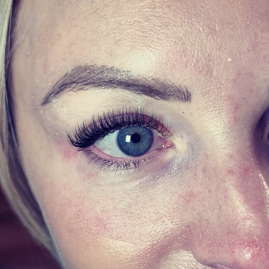 A hybrid lash set: soft volume mixed with classic lashes on a blue eye